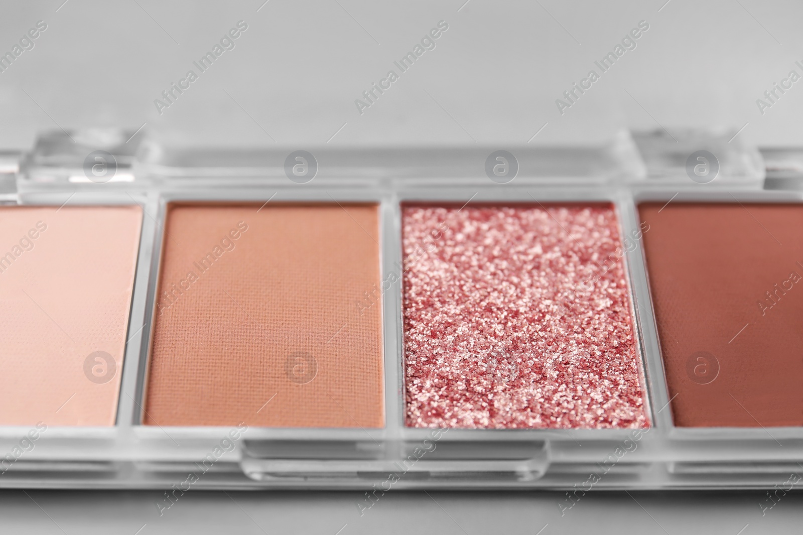 Photo of Beautiful eyeshadow palette on light gray background, closeup. Professional cosmetic product