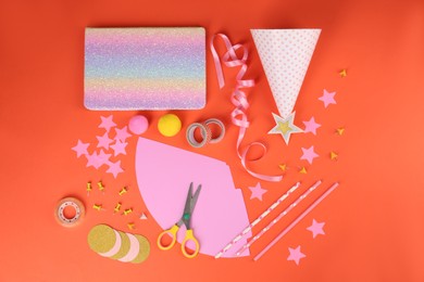 Photo of Different stationery and materials for creation of colorful party hats on orange background, flat lay. Handmade decorations