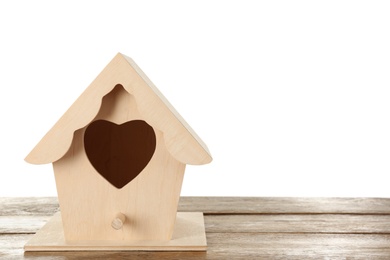 Photo of Beautiful bird house with heart shaped hole on wooden table against white background, space for text