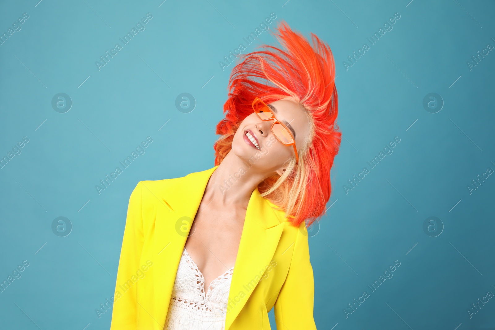 Photo of Beautiful young woman with bright dyed hair shaking head on turquoise background