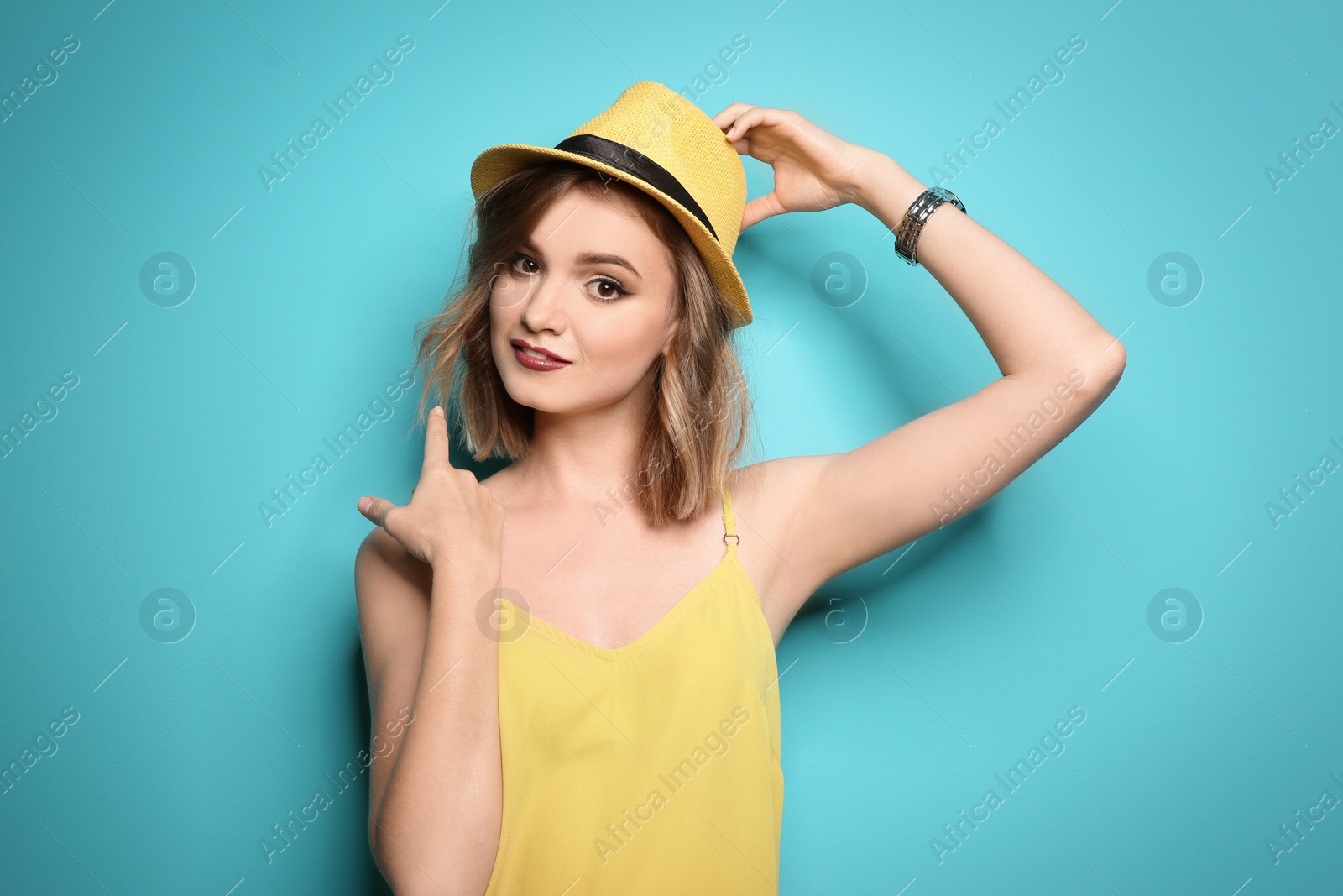 Photo of Beautiful young woman with stylish hat posing on color background