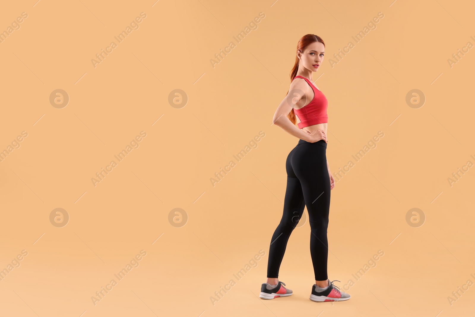 Photo of Young woman in sportswear on beige background, space for text