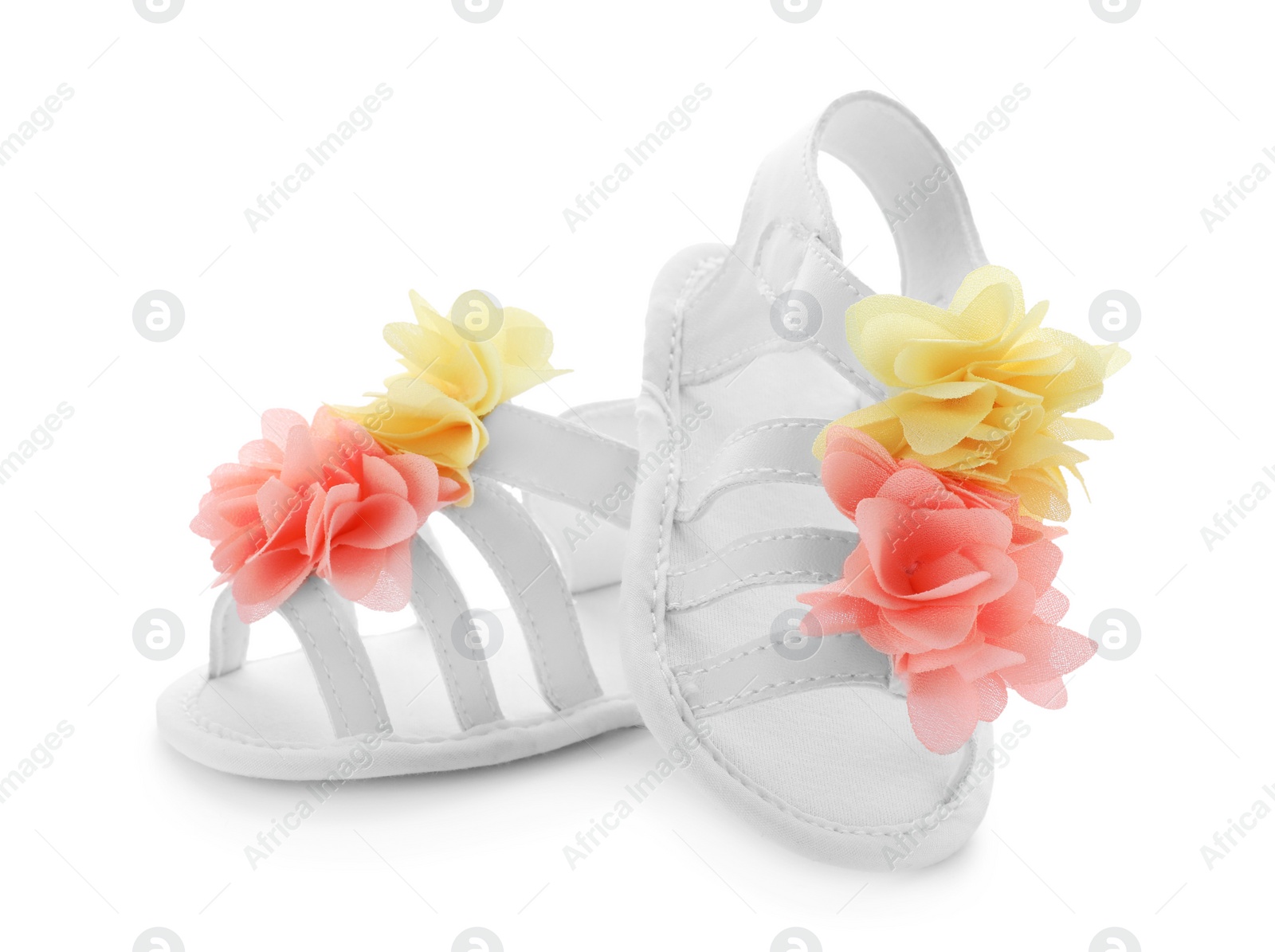 Photo of Pair of baby sandals decorated with flowers on white background