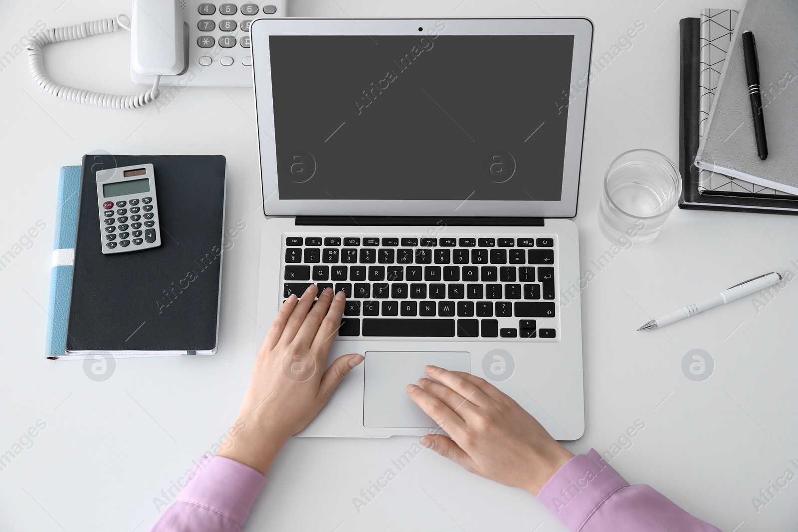 Photo of Young woman using modern laptop at table, top view