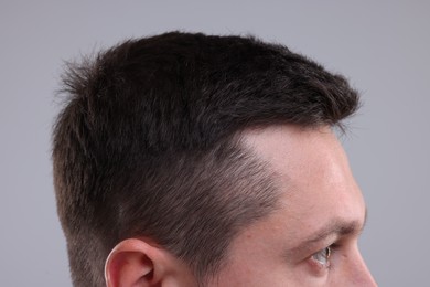 Photo of Man with healthy hair on grey background, closeup