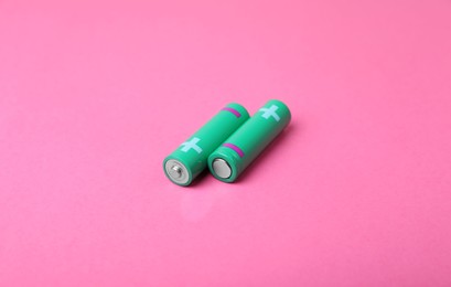 New AA size batteries on pink background