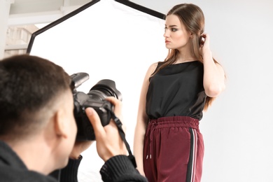 Photo of Beautiful young model posing for professional photographer in studio