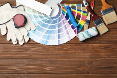 Photo of Set of decorator's tools on wooden background, flat lay