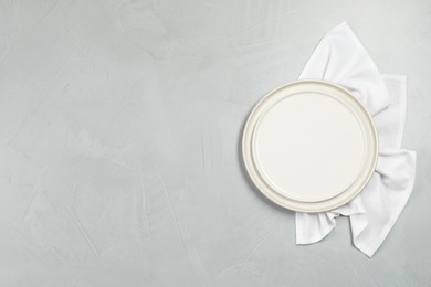 Elegant plate and napkin on grey table, top view. Space for text