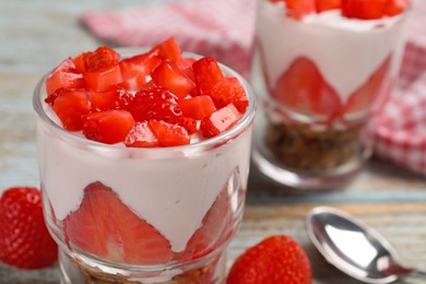 Glasses with delicious yogurt and strawberries on table, closeup