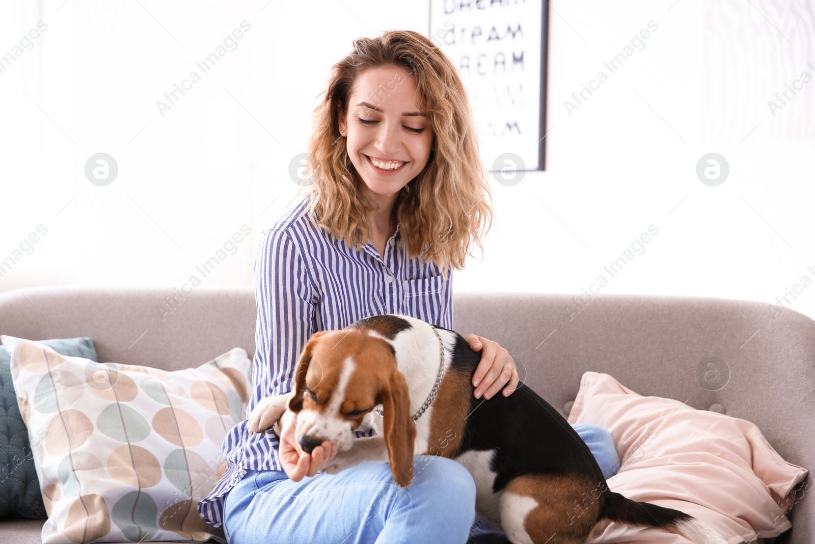 Photo of Young woman with her dog on sofa at home