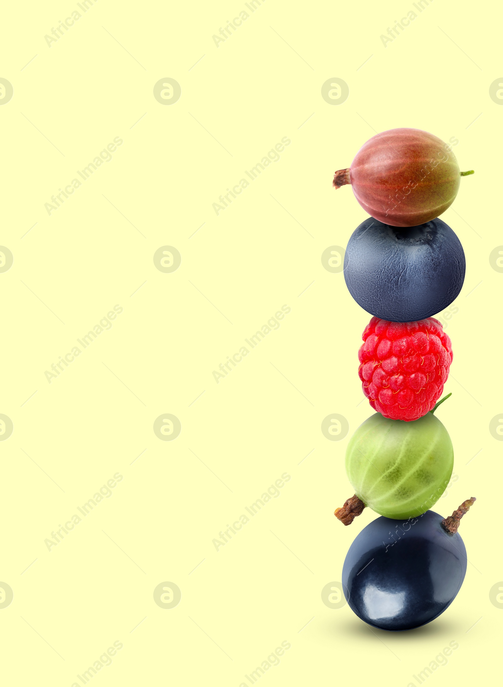 Image of Stack of different fresh tasty berries on honeydew color background, space for text