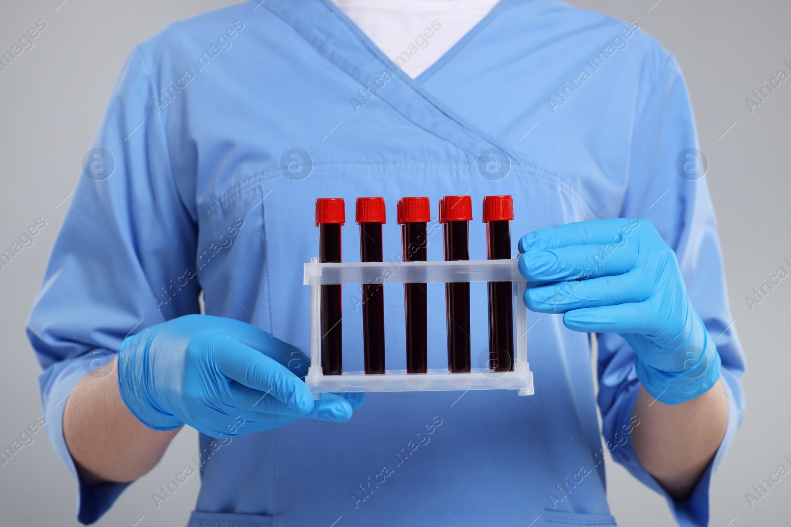 Photo of Laboratory testing. Doctor with blood samples in tubes on light grey background