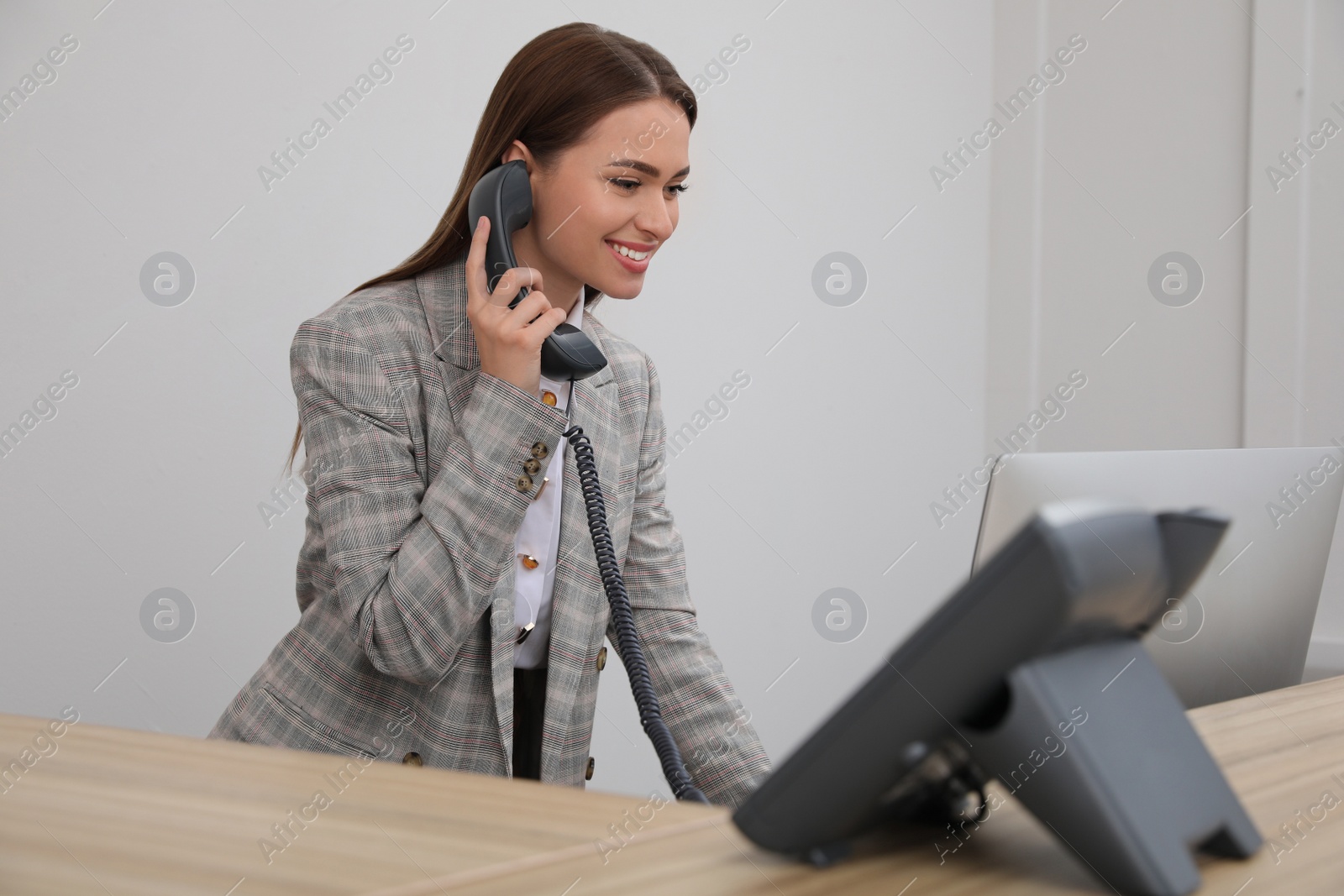 Photo of Female receptionist talking on phone at workplace