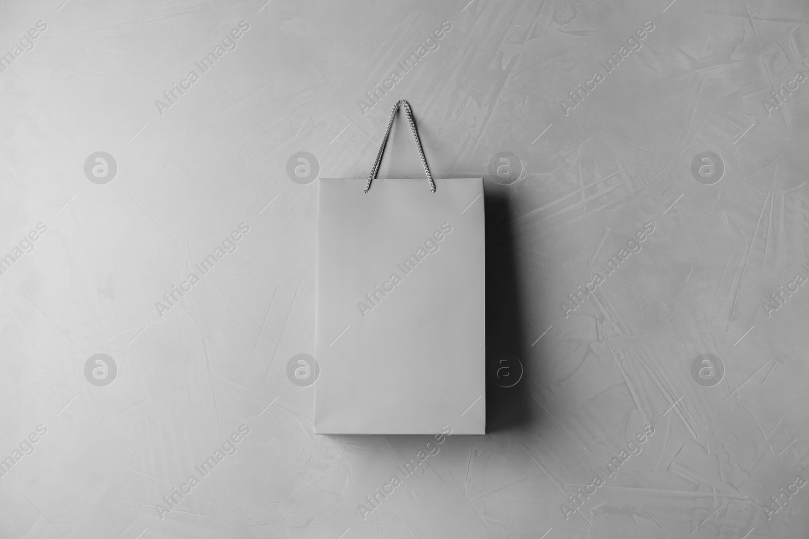 Photo of Paper shopping bag hanging on grey wall