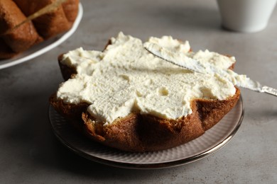 Slice of delicious Pandoro cake with cream on grey table