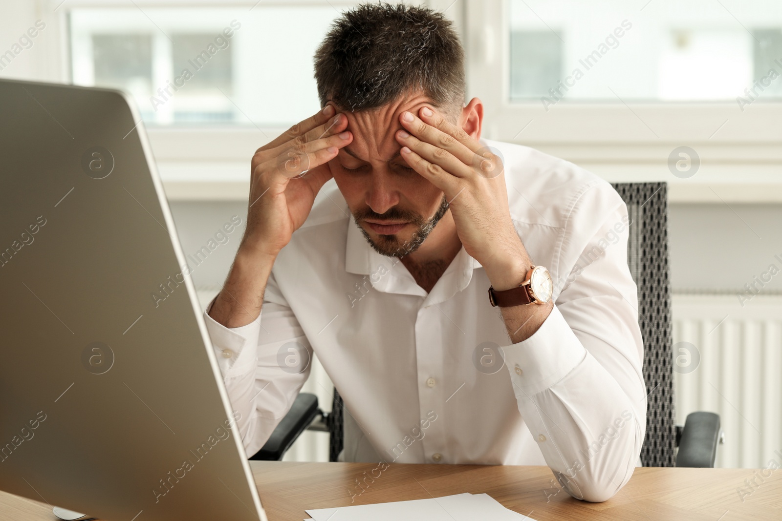 Photo of Sleep deprived man at workplace in office