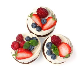 Sweet cupcakes with fresh berries on white background, top view