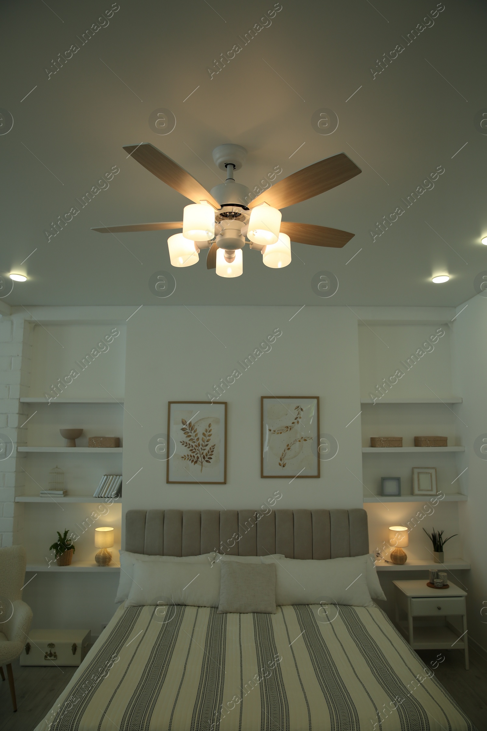 Photo of Ceiling fan, furniture and accessories in stylish bedroom