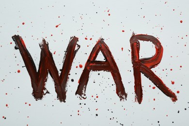 Photo of Word War written with black and red paint on white background, top view