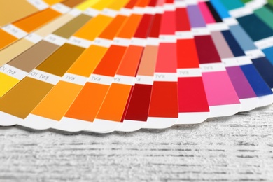 Photo of Color palette samples on wooden table, closeup