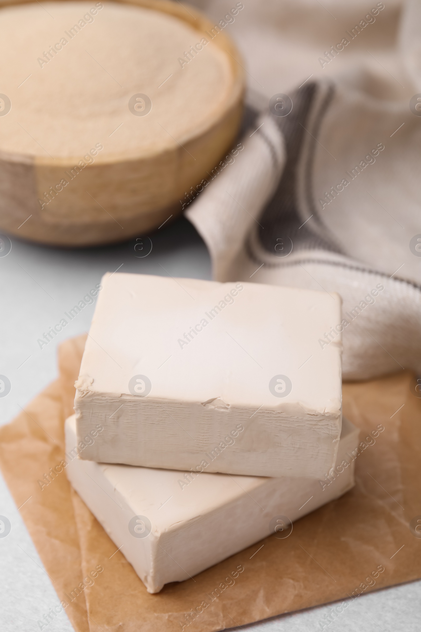 Photo of Blocks of compressed yeast on light gray table, closeup