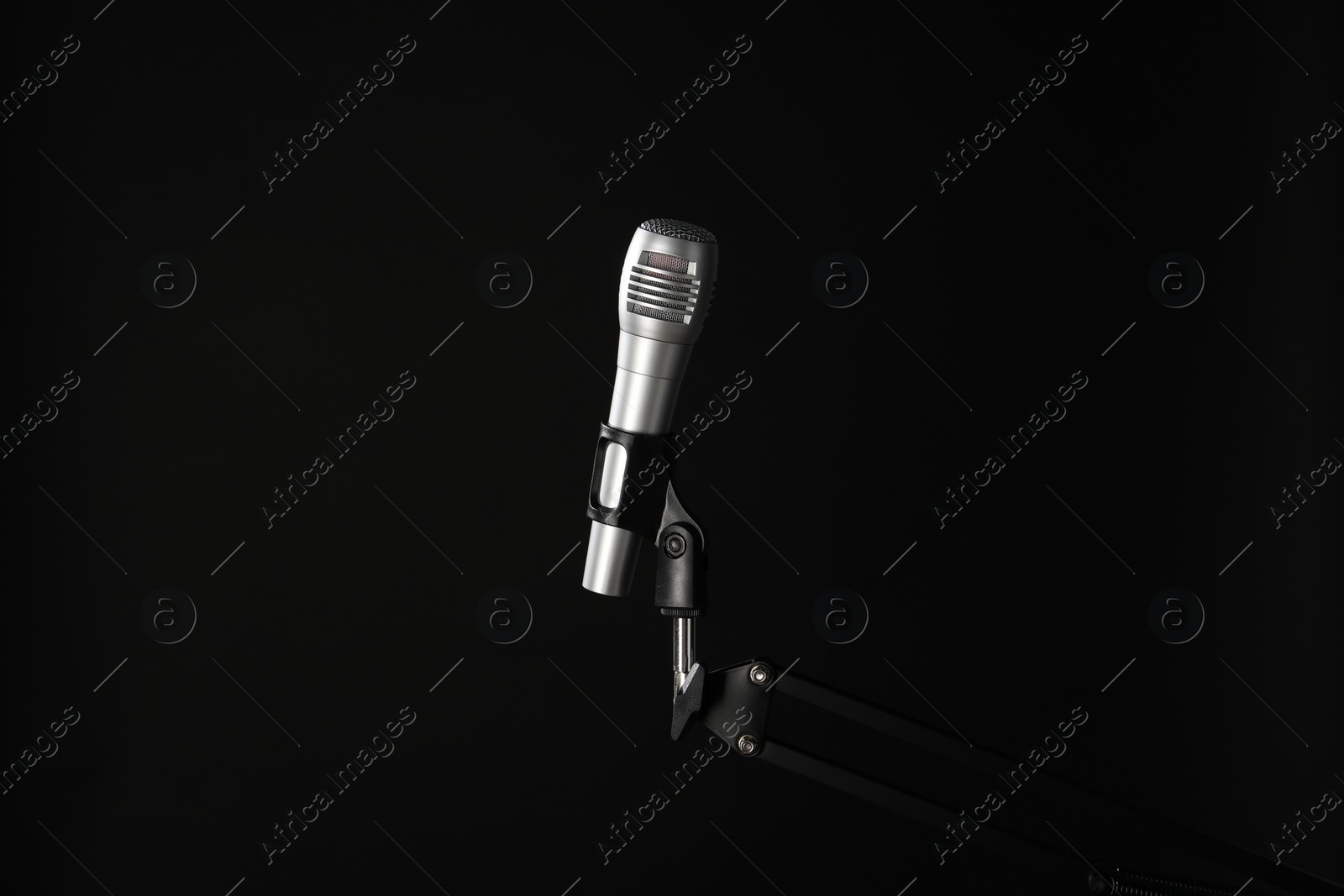 Photo of Stand with microphone on black background. Sound recording and reinforcement