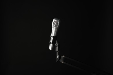 Stand with microphone on black background. Sound recording and reinforcement