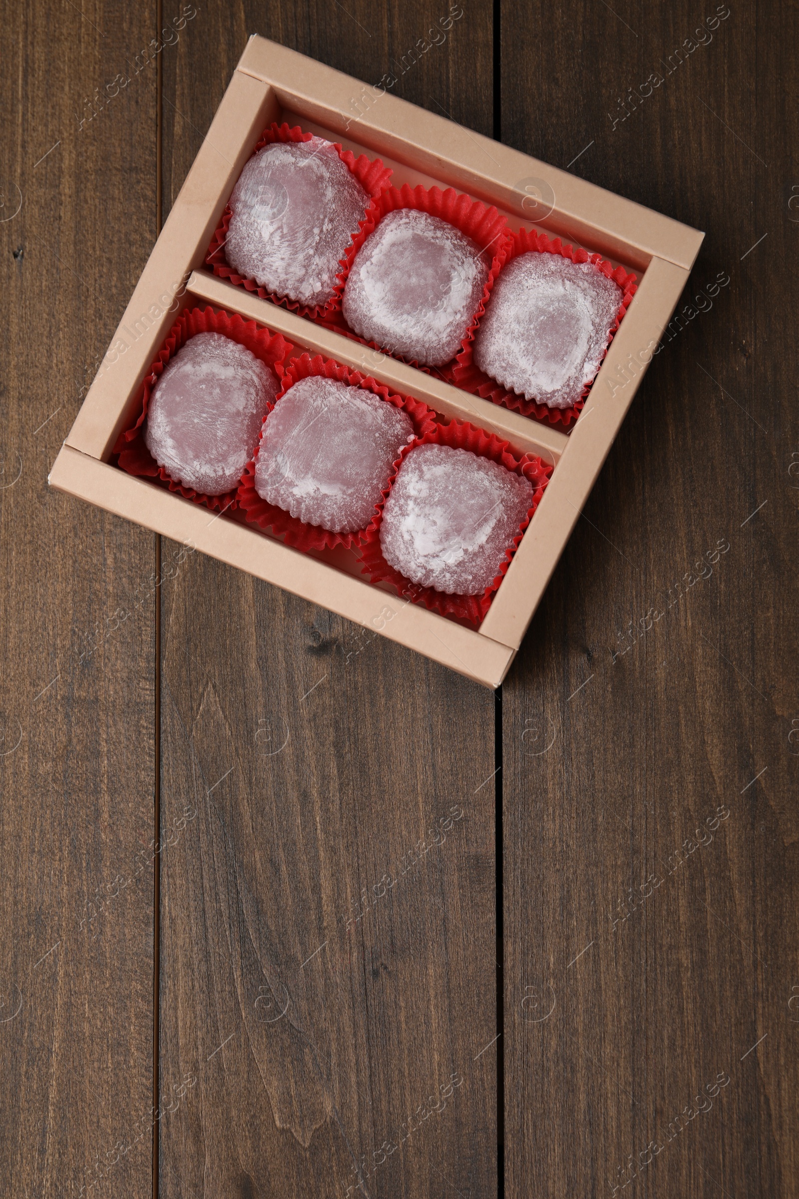 Photo of Box of delicious mochi on wooden table, top view with space for text. Traditional Japanese dessert