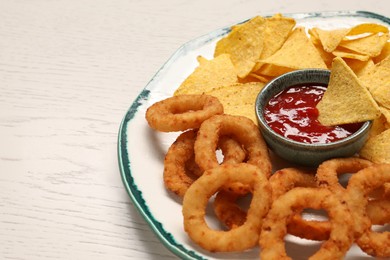 Photo of Tasty tortilla and fried onion rings with ketchup on white wooden table, closeup. Space for text