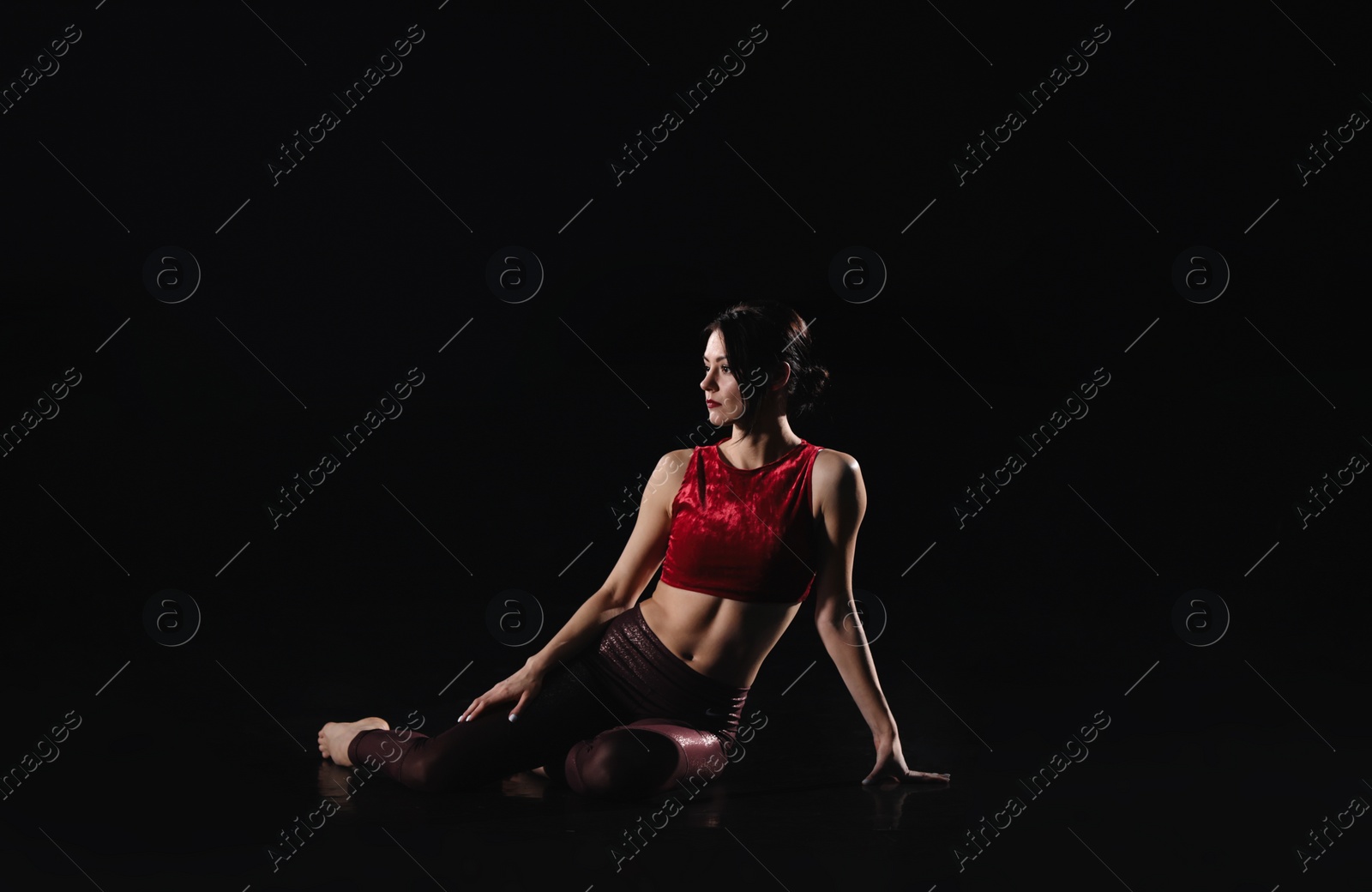 Photo of Young woman performing acrobatic element on stage indoors