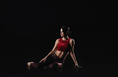 Photo of Young woman performing acrobatic element on stage indoors