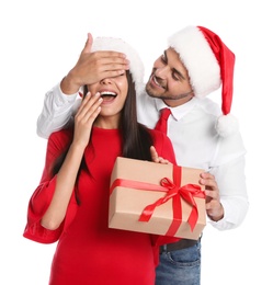 Young man presenting gift to his girlfriend on white background. Christmas celebration