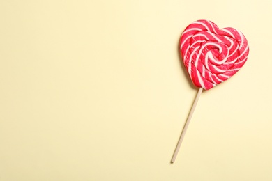 Photo of Sweet heart shaped lollipop on beige background, top view with space for text. Valentine's day celebration