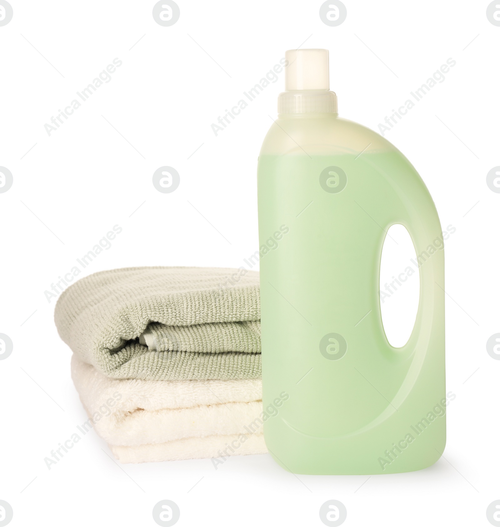 Photo of Bottle of fabric softener and stacked clean towels isolated on white