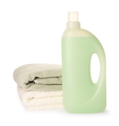 Photo of Bottle of fabric softener and stacked clean towels isolated on white