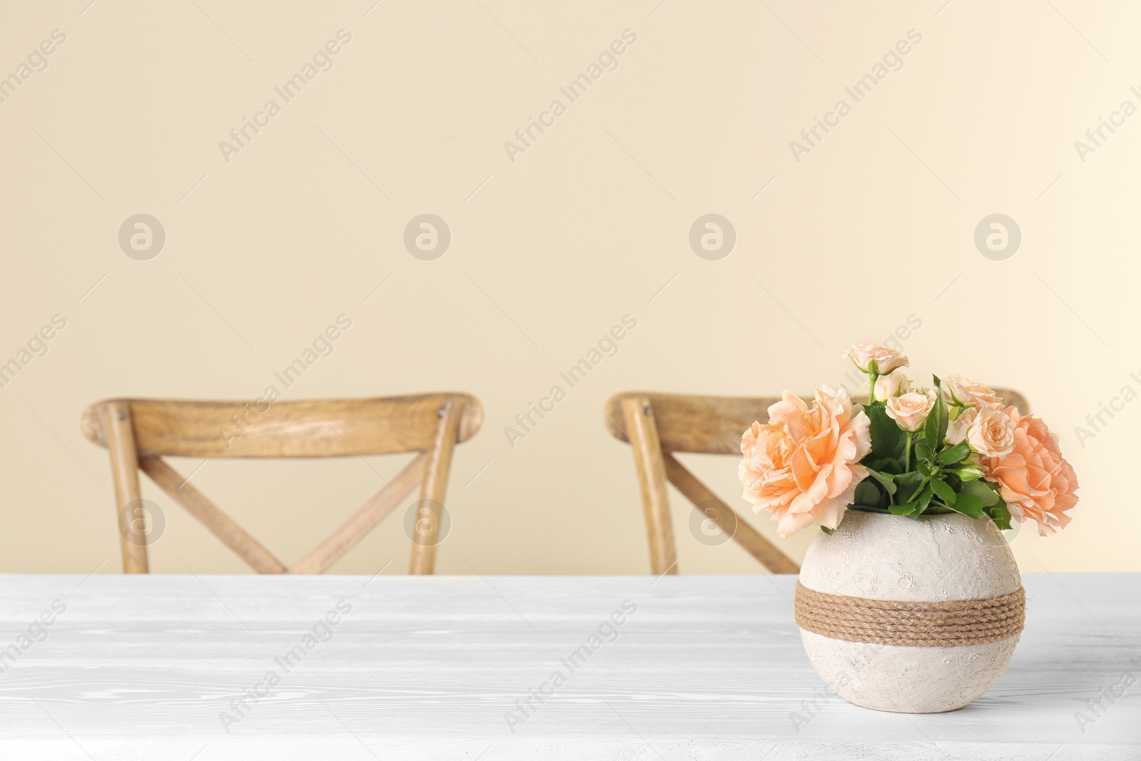 Photo of Vase with blooming flowers on table indoors