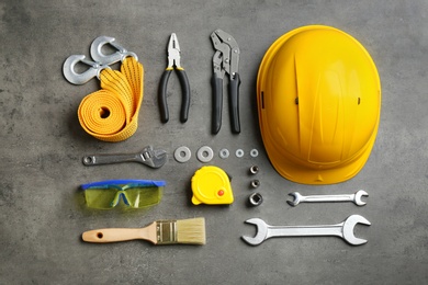 Photo of Flat lay composition with different construction tools on grey background