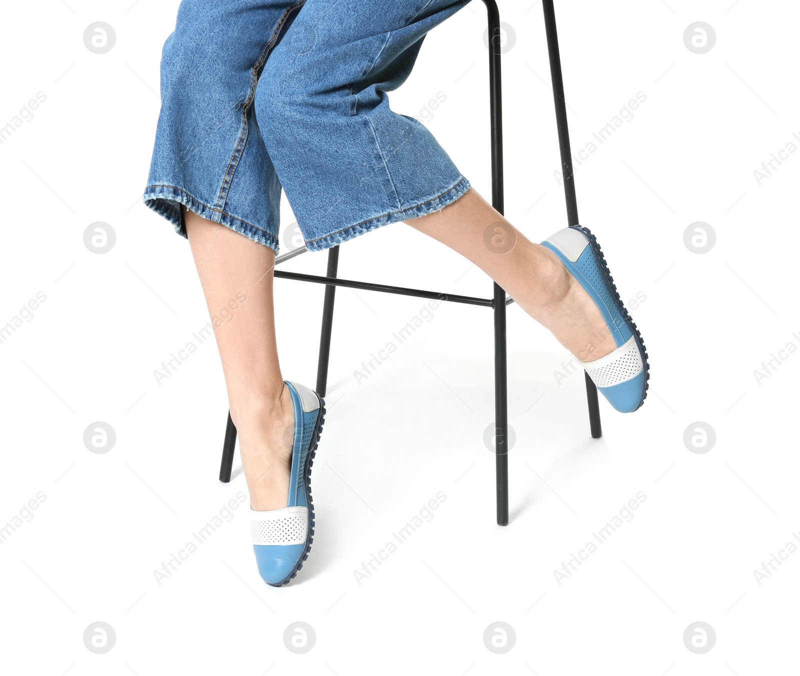 Photo of Woman in stylish shoes on stool against white background, closeup