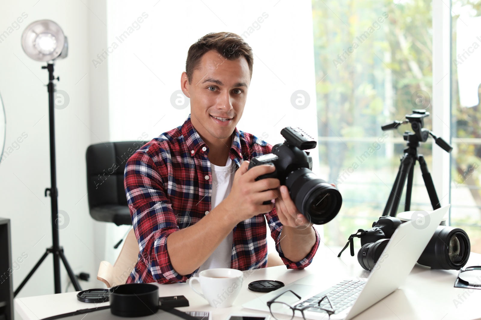 Photo of Portrait of photo blogger with camera and laptop at home. Online broadcast