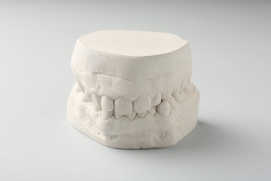 Dental model with gums on light grey background. Cast of teeth