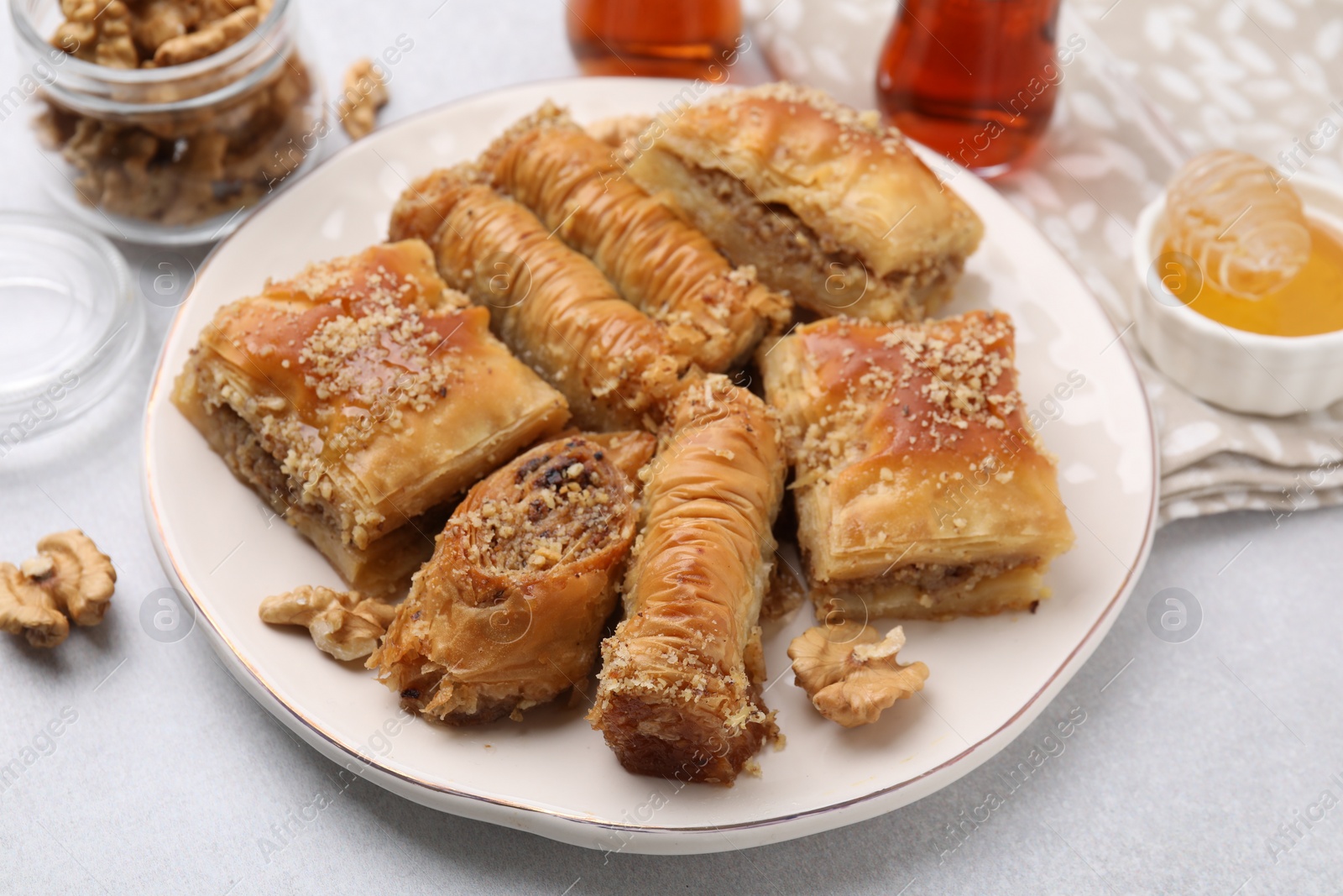 Photo of Eastern sweets. Pieces of tasty baklava on white table, closeup