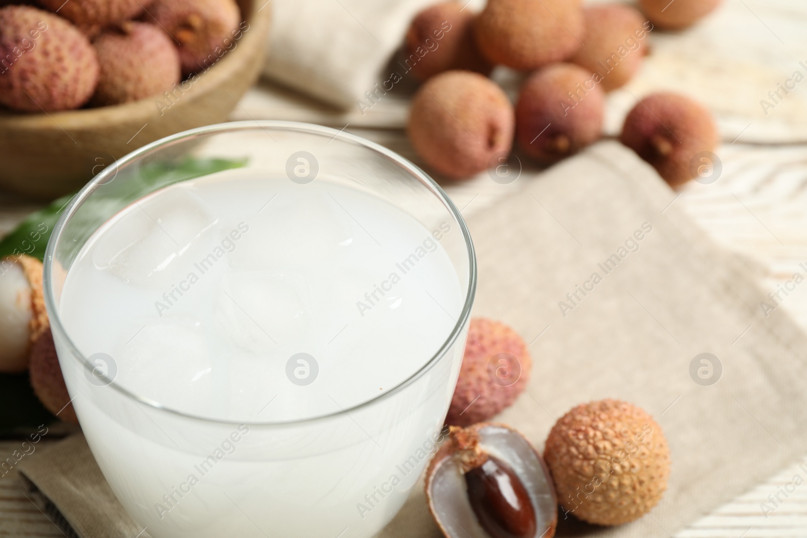 Photo of Freshly made lychee juice on white wooden table, closeup. Space for text