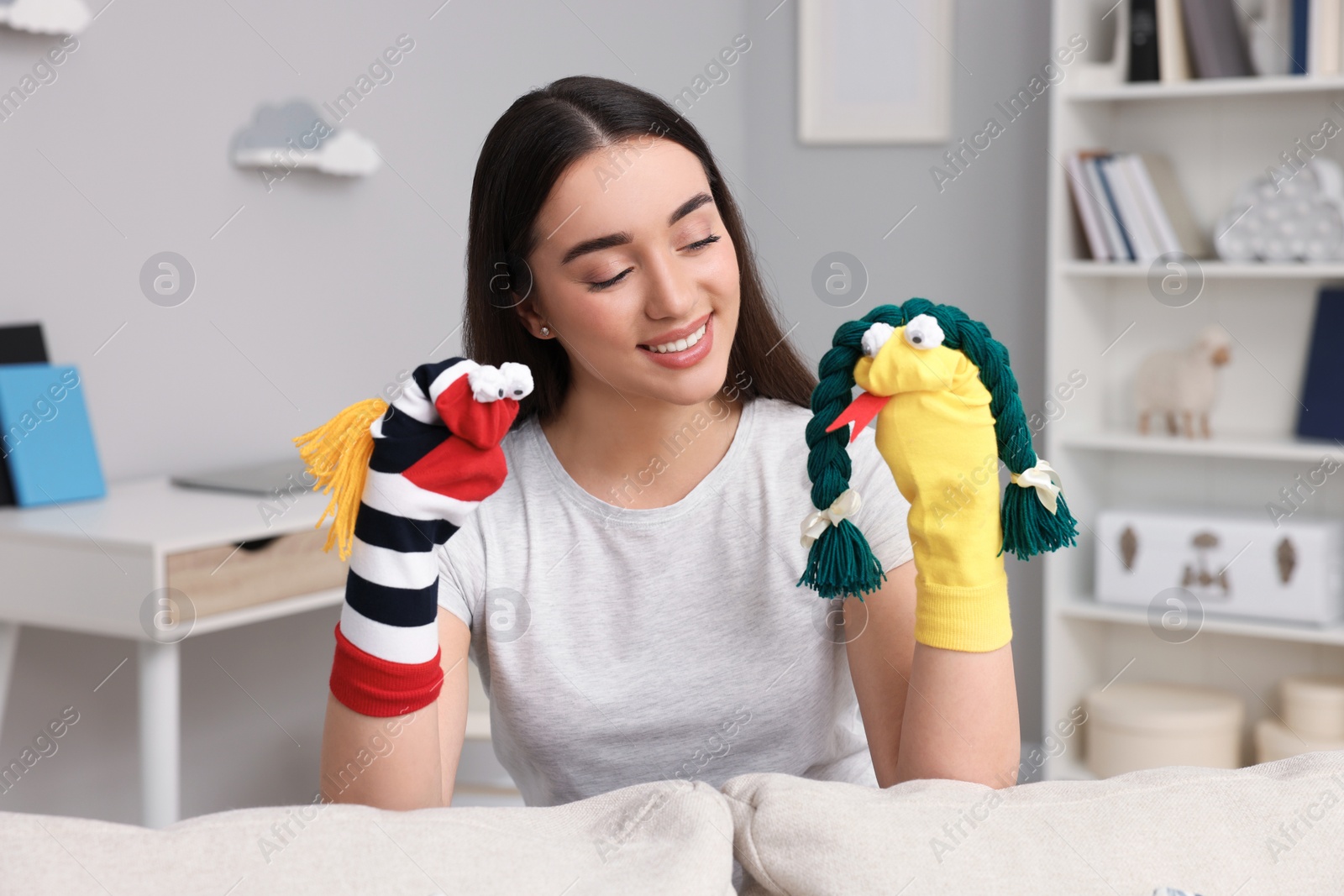 Photo of Happy woman performing puppet show at home