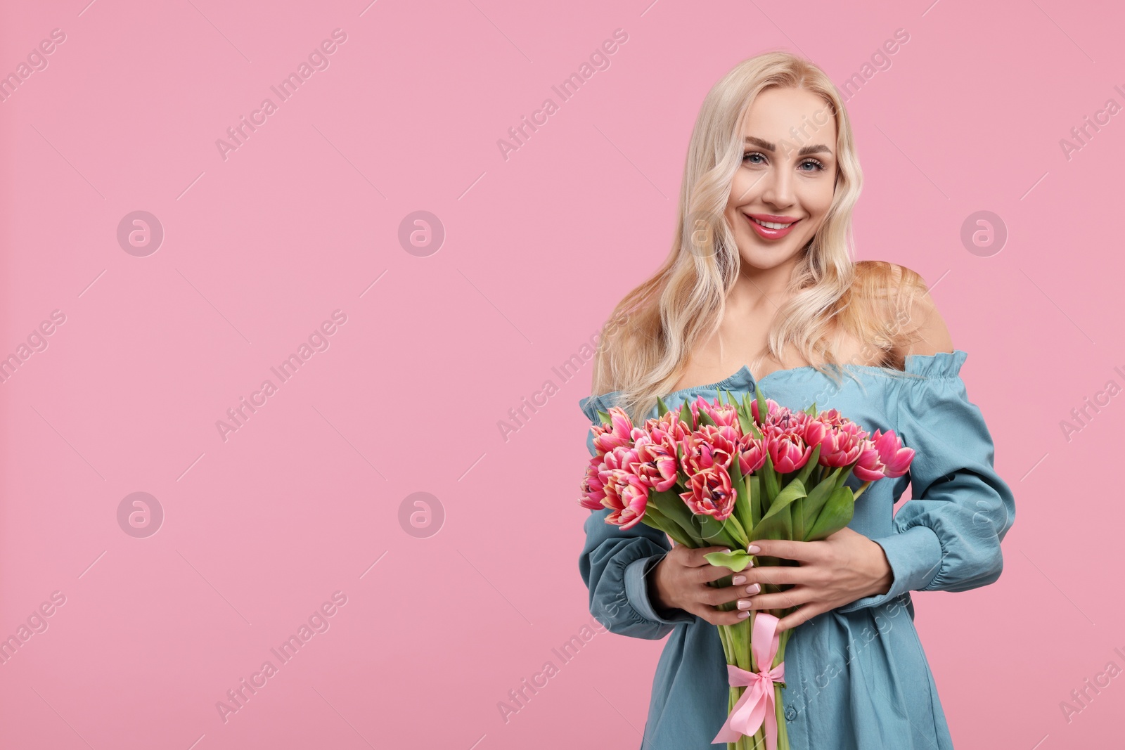 Photo of Happy young woman with beautiful bouquet on dusty pink background. Space for text