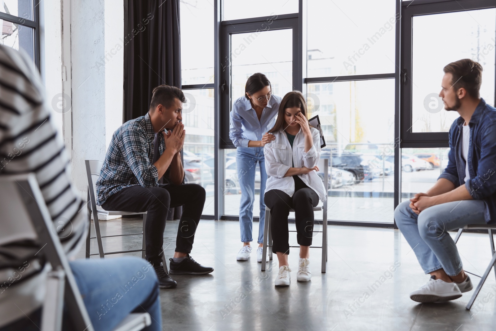 Photo of Psychotherapist working with patients in group therapy session indoors