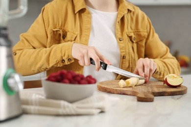 Woman preparing ingredients for tasty smoothie at white marble table in kitchen, closeup