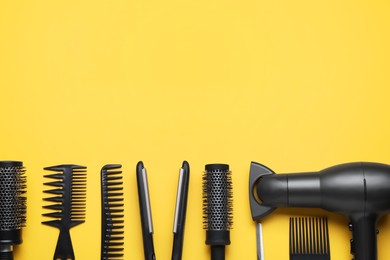 Photo of Flat lay composition of professional hairdresser tools on orange background, space for text