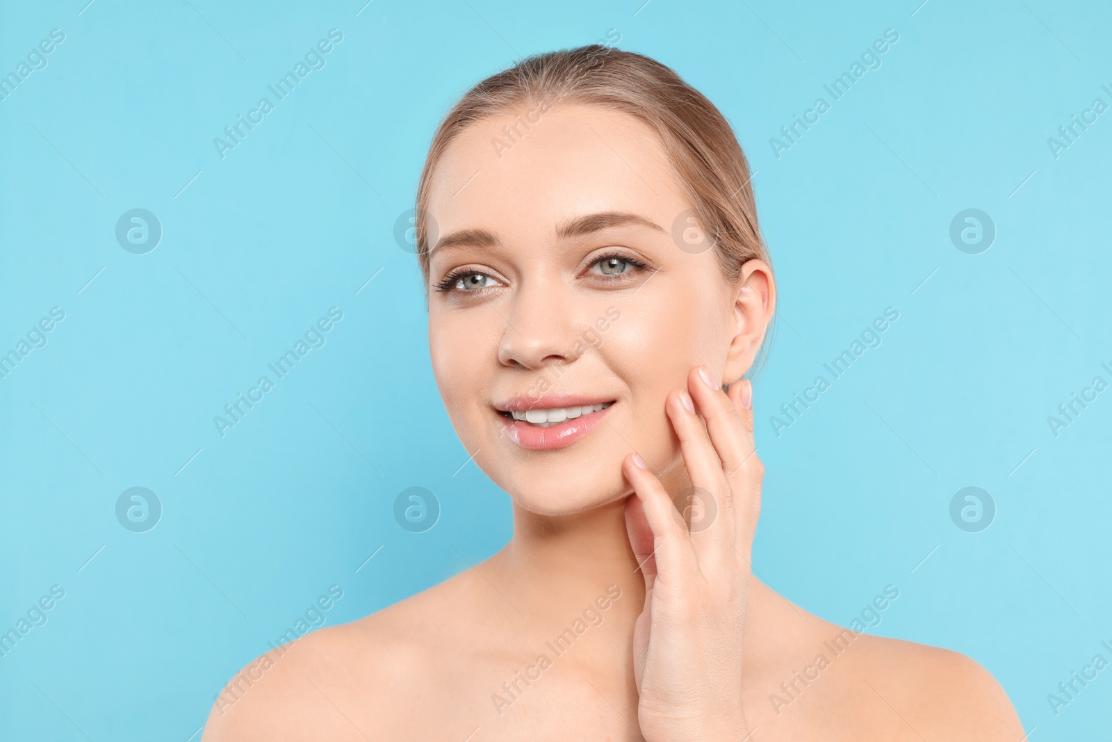 Photo of Portrait of young woman with beautiful face on blue background