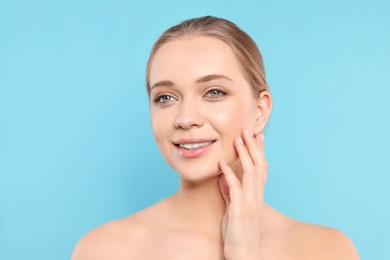 Photo of Portrait of young woman with beautiful face on blue background